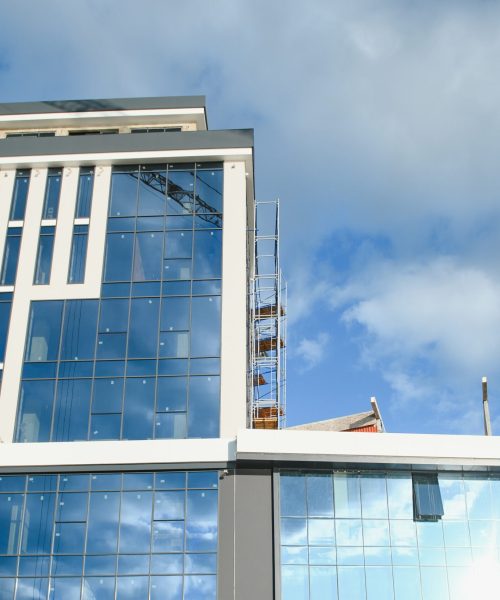 Modern building under construction against blue sky